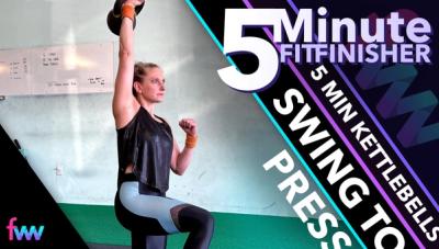 Kindal at the bottom of a lunge while pressing a kettlebell overhead.