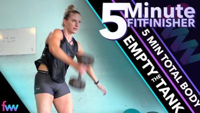 Kindal about midway through the dumbbell floor snatch. Her elbow has stopped moving and she is letting the weight travel up so she can then press it overhead.