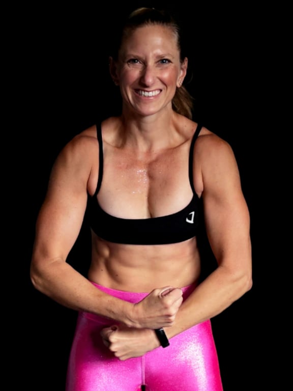 Kindal flexing because she gets results through focusing on consistency first and workouts second.